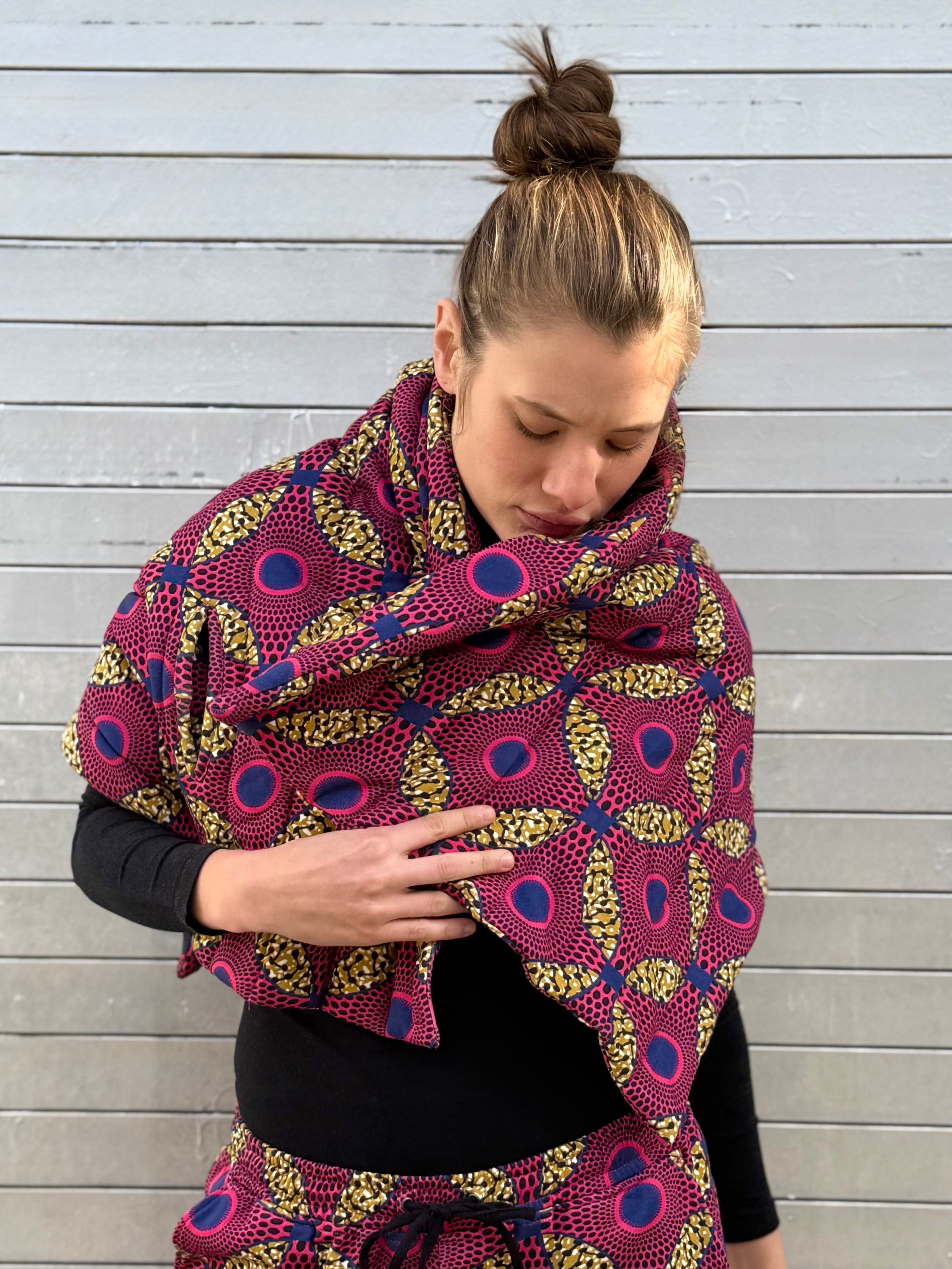 Close-up of the Ìmọ́lẹ̀ Pink Scarf featuring African-inspired patterns in pink, yellow, and navy tones. Designed by Lola Faturoti Loves and made by women artisans in India, this piece blends soft structure with bold heritage, crafted in organic cotton for ethical, joyful everyday wear.