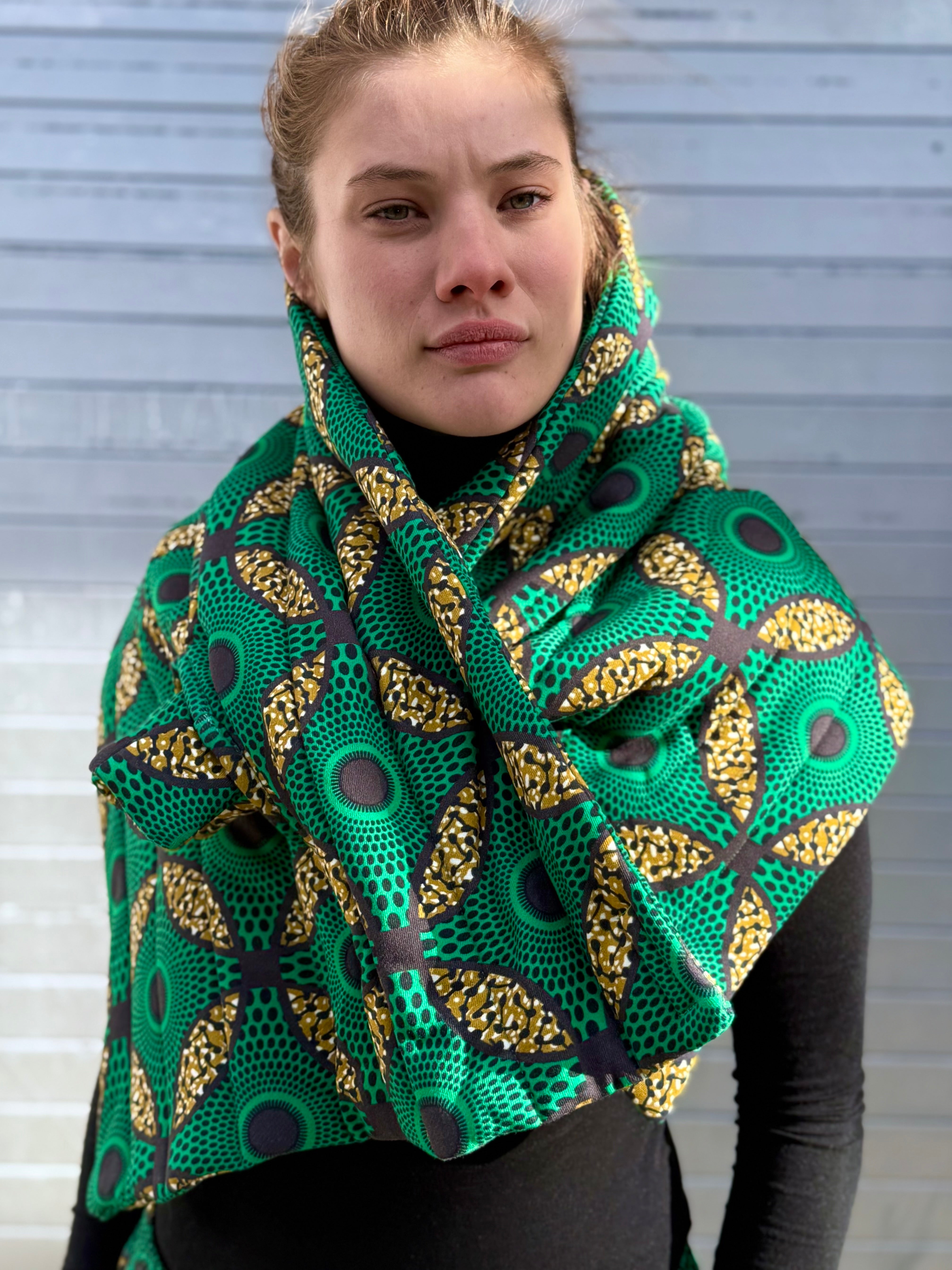 Front view of model wearing the Ìmọ́lẹ̀ Green Scarf, adorned with Yoruba-inspired geometric prints in green and yellow, handmade for sustainable elegance. Complete your conscious wardrobe with the Imole Green Scarf: a celebration of Yoruba design, organic cotton, and fair-trade craftsmanship.