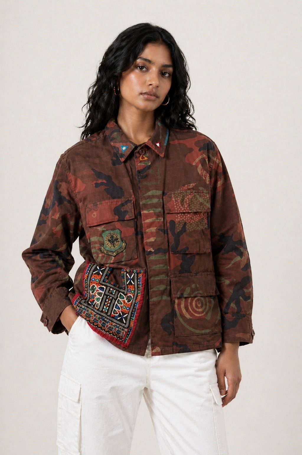 Exclusive reworked military jacket featuring earthy rust dye, subtle geometric patterning, and artisan mirror embroidery