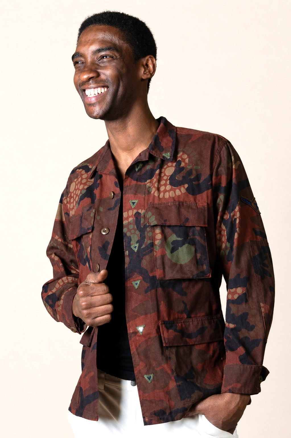 Exclusive reworked military jacket featuring earthy rust dye, subtle geometric patterning, and artisan mirror embroidery
